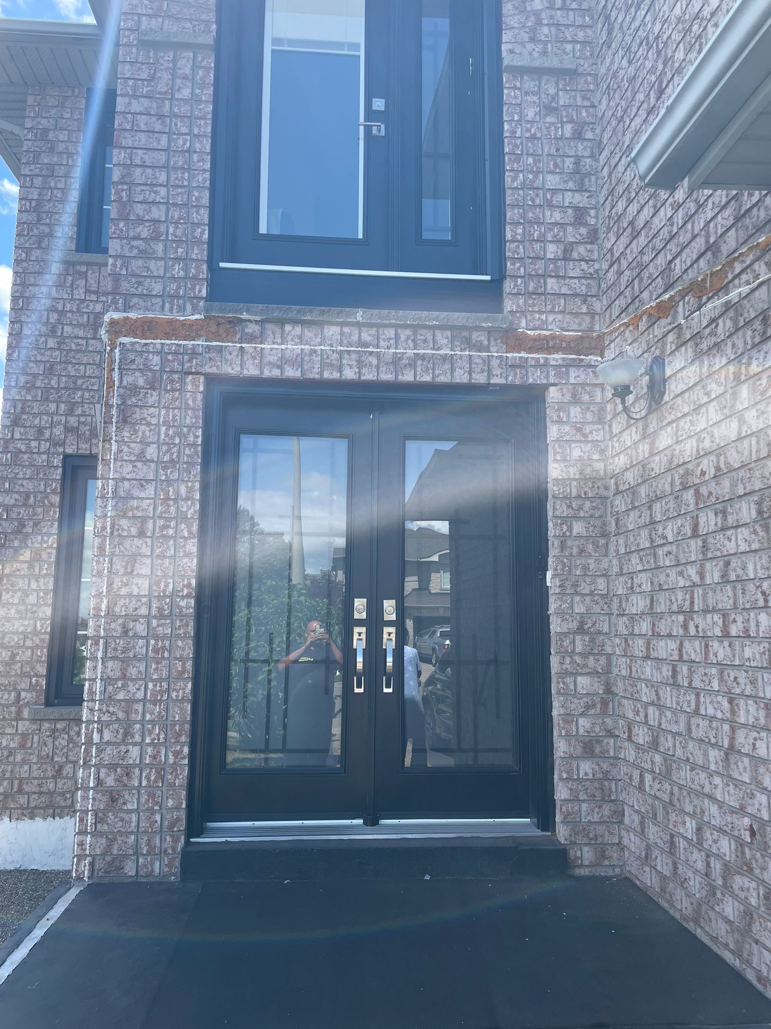 General Contractor St. Catharines Niagara Region 3 After: Black fiberglass double doors with transom on St. Catharines brick—secure, energy-efficient upgrade.