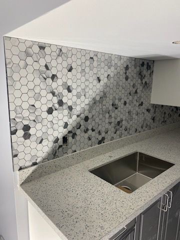 General Contractor St. Catharines Niagara Region 4 After: Gray hex mosaic backsplash over quartz counter in Niagara Falls kitchen remodel—modern durability for St. Catharines homes.